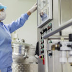 Female operator at pharmaceutical factory operating control panel - SIPMM
