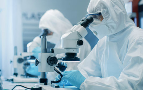 Manufacturing Engineers in Cleanroom Suits Using Microscopes - SIPMM